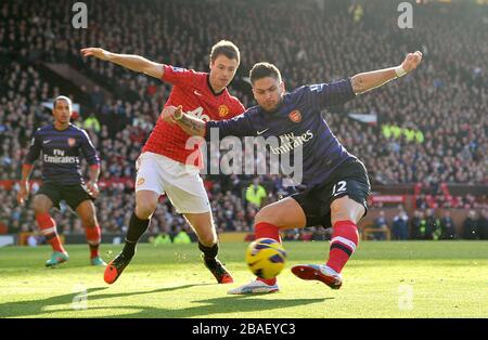 Olivier Giroud dell'Arsenal e Jonny Evans (a sinistra) del Manchester United combattono per la palla Foto Stock