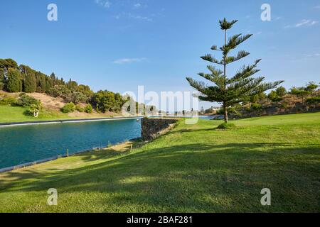 bellissimo paesaggio con cielo blu e uno splendido verde nel golf club con lago e ponte sull'erba Foto Stock