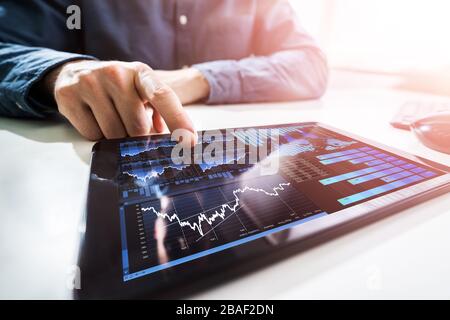 Primo piano della mano di un uomo d'affari che analizza il grafico sul tablet Foto Stock