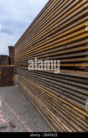 Costruzione di stand di una fiera regionale, costruzione di tende, pali di legno e tavole di legno per il pavimento della tenda sulla pila, tende sullo sfondo, alu Foto Stock