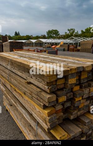 Costruzione di stand di una fiera regionale, costruzione di tende, pali di legno e tavole di legno per il pavimento della tenda sulla pila, tende sullo sfondo, alu Foto Stock