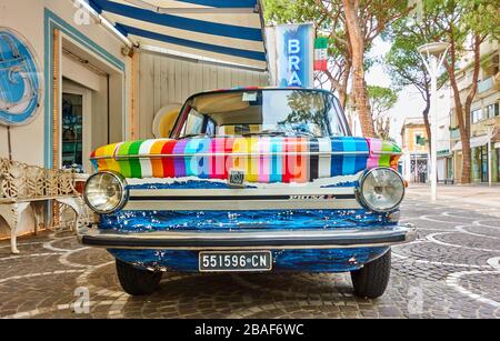 Cattollca, Rimini, Italia - 29 febbraio 2020: Vista frontale della colorata auto d'epoca NSU Prinz L parcheggiata accanto al negozio Brandina nella piccola città italiana Foto Stock