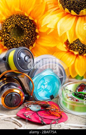 Pesca tackles, linee e mulinello con decorazione primaverile con girasoli e cuori rossi Foto Stock