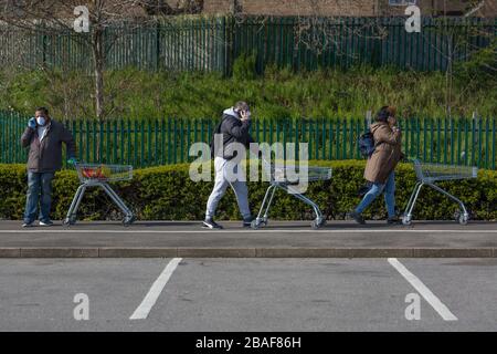 Asda Superstore, Leytonstone, Londra, Regno Unito. 27 marzo 2020. Le persone si accodano al di fuori del superstore di Asda a Londra Est mentre il governo si sposta nella fase di ritardo per cercare di controllare la diffusione di Covid-19 attraverso la capitale. Credit: Marcin Nowak/Alamy Live News Foto Stock