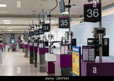 Edimburgo, Scozia, Regno Unito. 27 marzo 2020. Vista interna di un aeroporto di Edimburgo deserto durante la pandemia di coronavirus. Con pochissimi voli durante l'attuale crisi Covid-19 i passeggeri sono scarsi nell'edificio del terminal. Riga di contatori di check-in vuoti. Iain Masterton/Alamy Live News Foto Stock