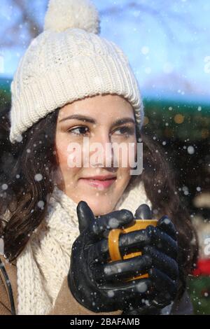 Giovane donna elegante in un mercato di natale Foto Stock