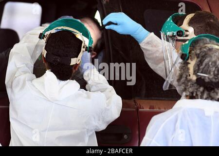 Lake Charles, Stati Uniti. 26 marzo 2020. La Guardia Nazionale della Louisiana si occupa di medicina con il 256° Fanteria Brigade Combat Team, somministrare i test del tampone nasale COVID 19 presso un sito di test drive through COVID-19 presso il Burton Coliseum il 26 marzo 2020 a Lake Charles, Louisiana. Credit: Matt Hecht/US Air Force/Alamy Live News Foto Stock