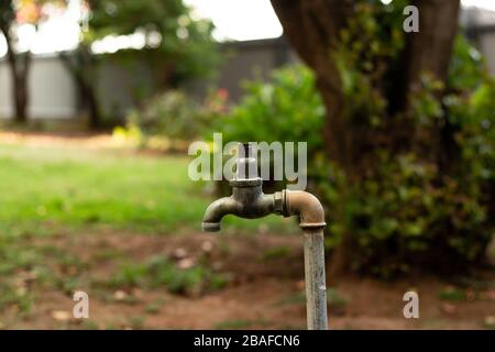 Rubinetto d'acqua rotto nel giardino Foto Stock