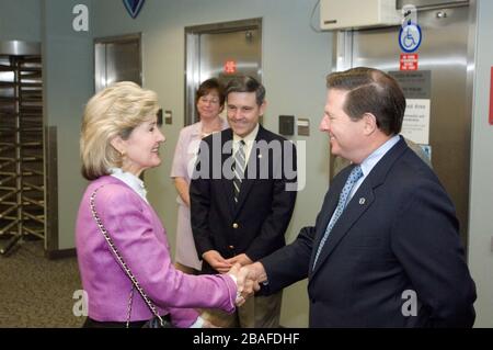 In questa foto rilasciata dalla National Aeronautics and Space Administration, il senatore degli Stati Uniti Kay Bailey Hutchison (repubblicano del Texas) e il Rappresentante degli Stati Uniti Tom Delay (repubblicano del Texas) si stringono le mani durante una visita al Johnson Space Center di Houston, Texas, il 5 agosto 2005. Robert D. Cabana, direttore aggiunto del JSC, è in background.Credit: NASA via CNP | utilizzo in tutto il mondo Foto Stock