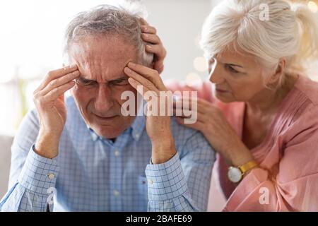 Donna anziana che consola suo marito a casa Foto Stock