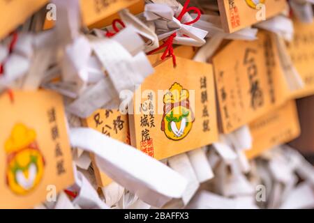 tokyo, giappone - 02 marzo 2020: Placche di legno Shinto decorate con un sacchetto radish e drawstring per la prosperità nel matrimonio e nel commercio nello Shinjoui Foto Stock