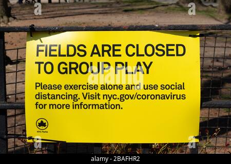 Un cartello giallo posto dal dipartimento di parchi e divertimenti di nyc legge che i campi di Inwood Park sono chiusi al gioco di gruppo a causa del coronavirus o del covid-19 Foto Stock