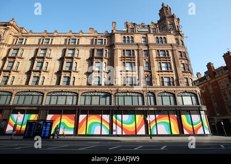 Le esposizioni dell'arcobaleno adornano le finestre del grande magazzino Harrods, Knightsbridge, Londra, mentre il Regno Unito continua a bloccarsi per contribuire a frenare la diffusione del coronavirus. Un totale di 759 persone sono morte nel Regno Unito dopo test positivi per il coronavirus a partire dalle 17:00 del 26 marzo, il Dipartimento della Salute ha detto. Foto Stock