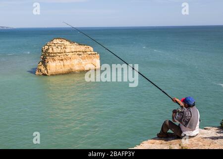 Pesca dalle scogliere sulla costa ovest di Alporchinhas, Algarve, Portogallo Foto Stock