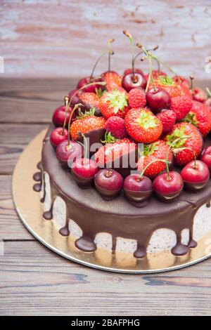 Cheesecake con cioccolato fuso e frutti di bosco freschi, fragole, ciliegie, lamponi. Foto Stock