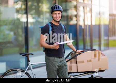 Messaggero di bicicletta che fa una consegna su una bici di carico Foto Stock