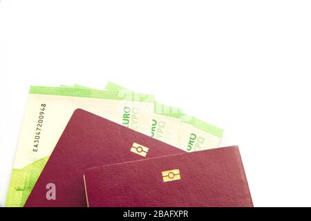 Banconote in euro in passaporto biometrico su sfondo bianco Foto Stock