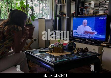 Caracas, Miranda, Venezuela. 27 marzo 2020. Una donna prega da casa sua, ascoltando la benedizione del Santo Padre. Papa Francesco benedice il mondo e dà la benedizione di Urbi et Orbi dalla Cattedrale e da Piazza San Pietro nella Città del Vaticano, in un atto storico dovuto alla pandemia di coronavirus che sta dilagando il mondo. Credit: Jimmy Villalta/ZUMA Wire/Alamy Live News Foto Stock