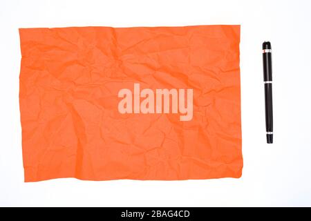 Carta rossa e penna sbriciolata su bianco Foto Stock