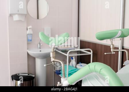 Interno in un ufficio medico. Sedia ginecologica, poggiapiedi visibili. Foto Stock