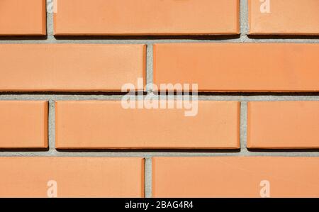 Tessitura della parete di una nuova casa di mattoni rossi illuminata dal sole. Sfondo Foto Stock