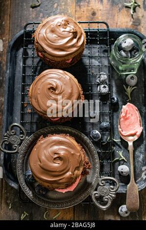 Muffin al cioccolato con crema. Dolce dessert vintage style. Cibo e bevande deliziosi Foto Stock