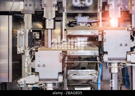 Linea industriale per il confezionamento di prodotti da forno. Confezionamento di pane in fabbrica.La macchina per il taglio e confezionamento in una fabbrica per la produzione Foto Stock