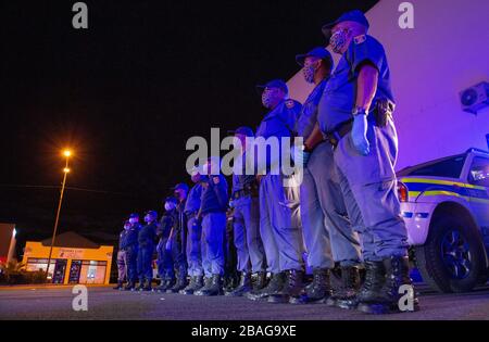 Città del Capo, Sudafrica. 27 marzo 2020. CITTÀ DEL CAPO, SUD AFRICA - Venerdì 27 Marzo 2020: I membri del Servizio di polizia sudafricano nel Somerset West e gli agenti dell'applicazione della legge della Città del Capo, sono informati prima di creare blocchi stradali per assicurarsi che i veicoli non essenziali non sono sulla strada. Il Presidente del Sudafrica, Cyril Ramaphosa, ha dichiarato un blocco nazionale di 21 giorni per combattere il virus COVID-19, che si diffonde rapidamente, o Coronavirus. Il pubblico è tenuto a rimanere a casa durante questo periodo. Credit: Roger Sedres/Alamy Live News Foto Stock