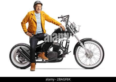 Motociclista maturo sorridente e seduto su una moto chopper isolato su sfondo bianco Foto Stock