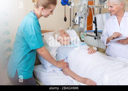 Paziente anziano con medico e infermiere in ospedale Foto Stock