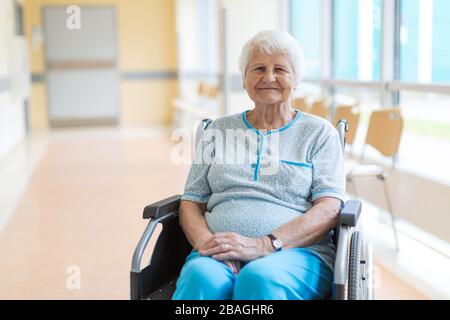 Donna anziana seduta in sedia a rotelle in ospedale Foto Stock