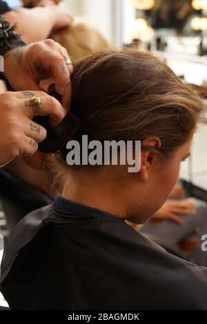 Uomo che styling capelli della ragazza giovane durante la settimana di Moda di New York. Foto Stock