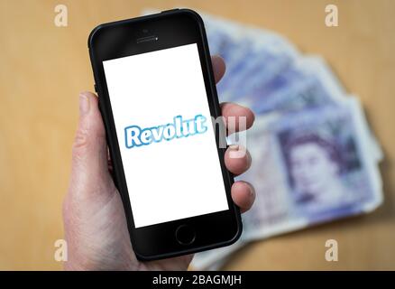 Una donna che guarda il logo Revolut Bank su un telefono cellulare. (Solo per uso editoriale) Foto Stock