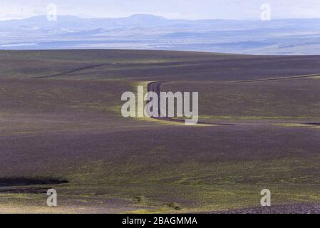 Donna in piedi nel mezzo del nulla su strada sterrata in altopiani Foto Stock