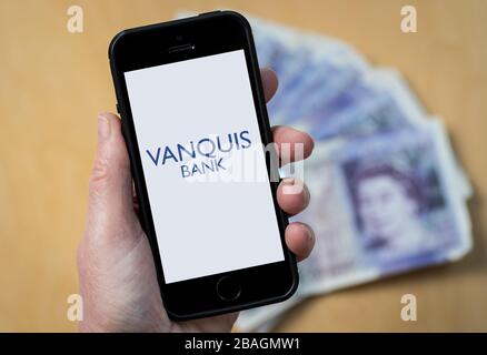 Una donna che guarda il logo Vanquis Bank su un telefono cellulare. (Solo per uso editoriale) Foto Stock