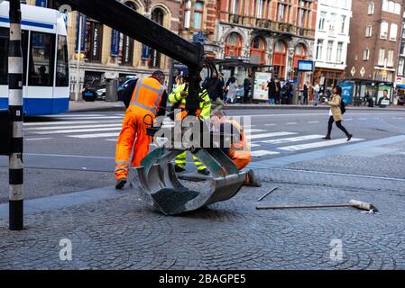 Amsterdam, Paesi Bassi - 7 settembre 2018: Lavoratori che asfaltano una strada con una gru idraulica con morsetto ad Amsterdam, Paesi Bassi Foto Stock