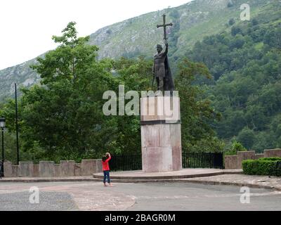 Bambina con blusa rossa che fotografa la statua di Don Pelayo a Covadonga (Asturias - Spagna) Foto Stock
