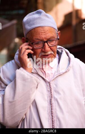 Fotografia di strada della gente locale in abbigliamento tradizionale, facendo il loro commercio quotidiano. Le foto vengono scattate all'interno della Medina di Marrakech, Marocco. Foto Stock