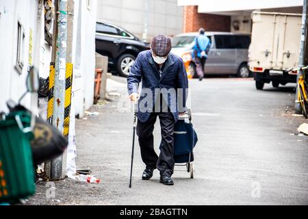 Uomo anziano che indossa una maschera protettiva durante la pandemia di Coronavirus a Seoul, Corea del Sud Foto Stock