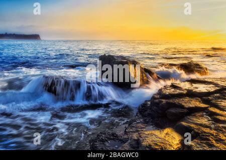 Rocce di arenaria erose alle spiagge settentrionali di Sydney intorno a Turimetta dirigersi all'alba. Foto Stock