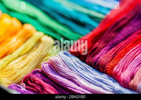 Un mix di colorati fili mouline che si trovano in diagonale a colori graduati, piatto disposizione di fili, texture sfondo. Foto Stock