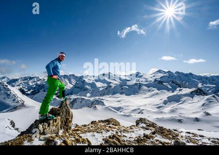 Uomo, tour sciistico si affaccia sulle catene montuose innevate, tour sciistico, panorama montano, vista da Geierjoch alle Alpi Olperer e Zillertaler Foto Stock