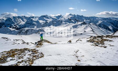 Uomo, tour sciistico si affaccia sulle catene montuose innevate, tour sciistico, panorama montano, vista da Geierjoch alle Alpi Olperer e Zillertaler Foto Stock