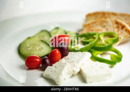 Vista poco profonda del semplice piatto di meze greco; con verdure, pita e feta Foto Stock