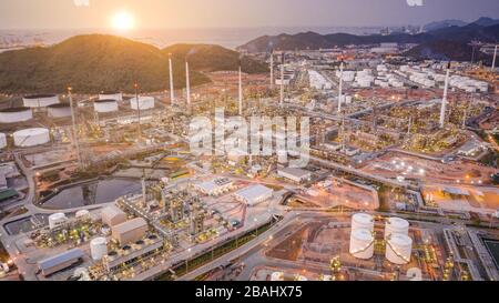 Grandi aziende industriali di raffineria di petrolio e gas, vista aerea di impianti industriali, serbatoi di stoccaggio del petrolio e gasdotto in background tramonto Foto Stock