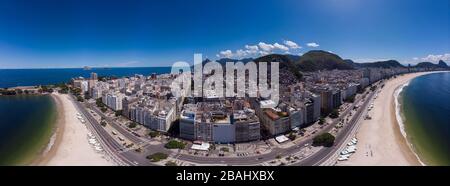 Ampio panorama aereo vicino alla spiaggia vuota di Copacabana e viale tra il monte Sugarloaf e il forte di Copacabana durante lo scoppio del virus COVID-19 Corona Foto Stock