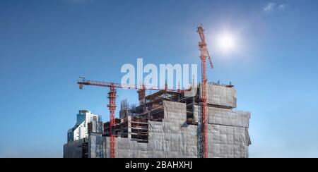 La vista panoramica dei lavoratori sta lavorando su grandi cantieri e molte gru stanno lavorando nel settore dei nuovi cantieri industriali. Foto Stock