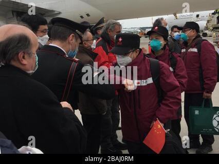 Pechino, Cina. 28 Marzo 2020. La gente del posto accoglie i membri della terza equipe medica cinese con un gomito a gomito invece di una stretta di mano quando i medici arrivano all'aeroporto di Milano Malpensa, Milano, 25 marzo 2020. Un team di 14 esperti medici della provincia del Fujian del sud-est della Cina è arrivato a Milano con un volo charter in Italia mercoledì per aiutare la lotta del paese europeo contro l'epidemia di COVID-19. Credit: Xinhua/Alamy Live News Foto Stock