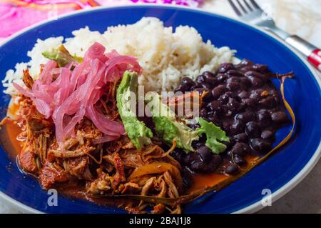 Cochinita pibil, piatto di maiale messicano arrostito al forno dalla penisola dello Yucatan, servito con riso, fagioli e condimenti tradizionali. Tacos dal Messico. Foto Stock