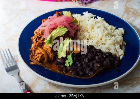 Cochinita pibil, piatto di maiale messicano arrostito al forno dalla penisola dello Yucatan, servito con riso, fagioli e condimenti tradizionali. Tacos dal Messico. Foto Stock